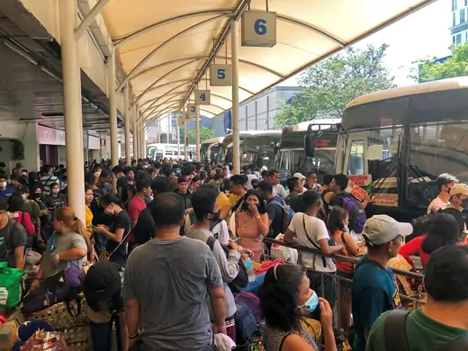 Passengers wear protective masks while waiting at the Araneta Center Bus Terminal in Cubao, Quezon City, Philippines, on March 13, 2020, following President Rodrigo Duterte's announcement of a local travel ban in the Philippine capital