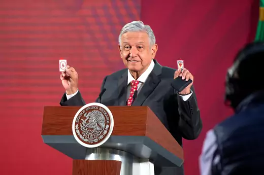 Mexico's President Andres Manuel Lopez Obrador shows his amulets, which he says serves him as a "protective shield" against the coronavirus disease (COVID-19) along with his honesty and not allowing corruption, during a news conference at the National Palace in Mexico City, Mexico March 18, 2020.
