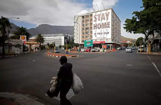 A man walks past a poster covering the side of a building ahead of a 21 day lockdown aimed at limiting the spread of coronavirus disease (COVID-19), in Cape Town, South Africa.
