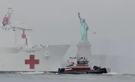 A naval hospital ship sails by the Statue of Liberty in New York.