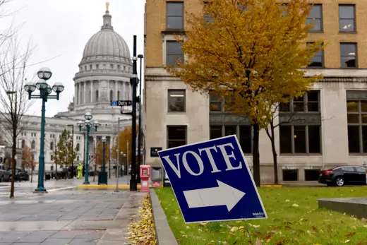 A blue sign that says "VOTE" with an arrow points voters toward a polling station in Milwaukee, Wisconsin, during the 2018 midterm elections.