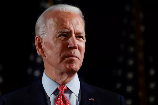 Former Vice President Joe Biden stands alone in a dark room to address the coronavirus pandemic last March. 