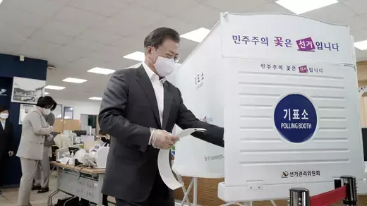 South Korean President Moon Jae-in wears a mask and plastic gloves to protect against COVID-19 as he votes in the parliamentary elections at a polling station in Seoul, South Korea, on April 10, 2020.