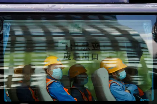 Workers leave a construction site at the end of their shift in the Central Business District in Beijing on April 16, 2020.