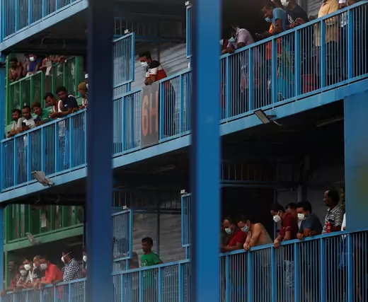Migrant workers look out from their balconies at Punggol S-11 dormitory, during the coronavirus outbreak in Singapore on April 6, 2020.