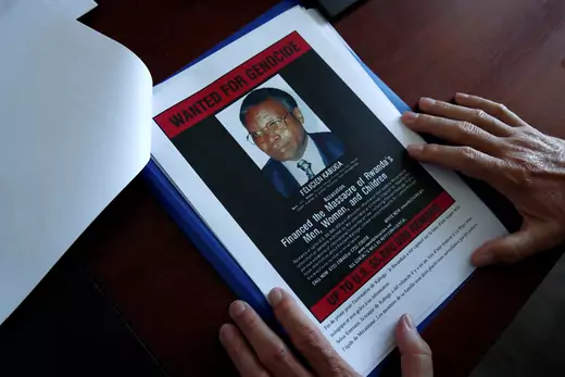 Eric Emeraux, head of the Gendarmerie's Central Office for Combating Crimes Against Humanity, Genocides and War Crimes (OCLCH), diplays documents with a wanted poster depicting a photograph of Felicien Kabuga during an interview with Reuters at his office, about the arrest of Rwandan genocide fugitive suspect Felicien Kabuga, in Paris, France, May 19, 2020