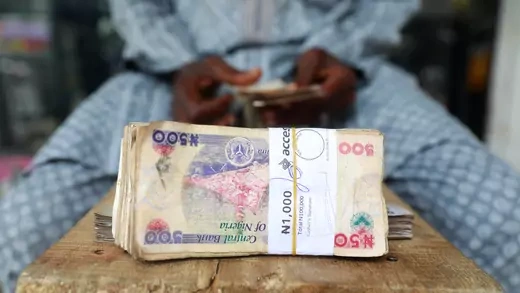 A money changer counts Nigerian currency notes for a customer in Nigeria's commercial capital, Lagos, Nigeria, on March 16, 2020.