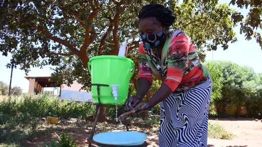 Farmer Leticia Kangwa uses a hand washing station she installed outside her home after learning about how to prevent the spread of COVID-19, in April 2020, in Zambia.
