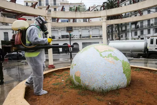A worker wearing a protective suit disinfects a globe-shaped public garden, following the outbreak of coronavirus disease (COVID-19), in Algiers, Algeria, on March 23, 2020. 