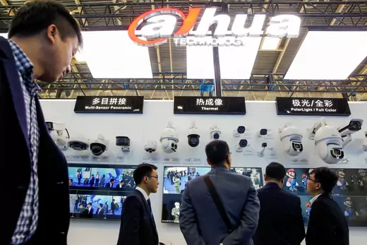 Visitors look at CCTV cameras at the stall of the video surveillance product maker Dahua Technology.