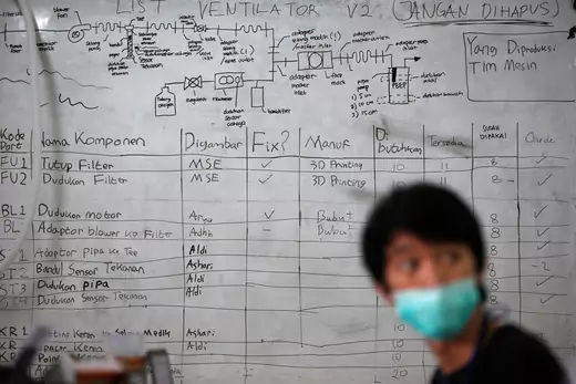 A volunteer wearing protective mask looks on at a workshop making "Vent-I", an innovation ventilator machine focused on Continuous Positive Airway Pressure (CPAP), commonly used in obstructive sleep apnea treatment, for coronavirus disease (COVID-19) patients, in Bandung, West Java province, Indonesia.