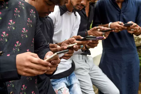 A group of young people look at their smart phones