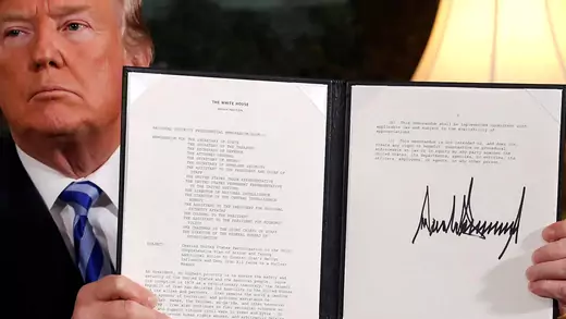 President Donald Trump holds up a proclamation declaring his intention to withdraw from the Iran nuclear deal.