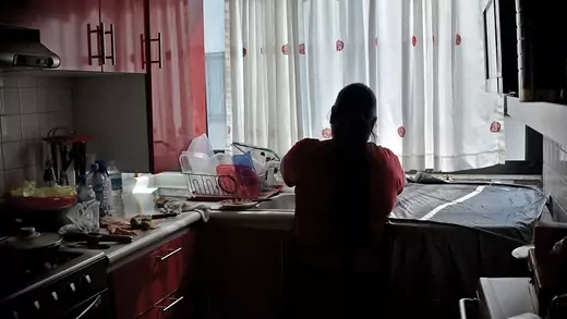 A woman washes dishes in a kitchen