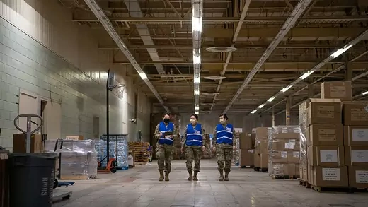 Members of the Oklahoma National Guard Oklahoma National Guard walk toward the front of the Strategic National Stockpile Warehouse after unloading medical supplies.
