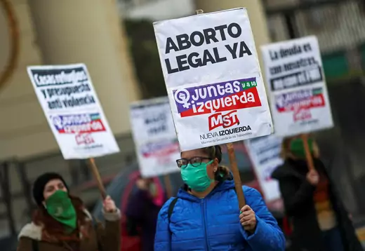 A demonstrator wearing a face mask holds a placard that reads "Legal Abortion Now", on the 5th anniversary of the "Ni Una Menos" movement, in Buenos Aires, Argentina June 3, 2020.
