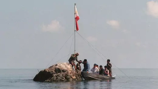 Philippine Navy personnel plant a flag at the disputed Scarborough Shoal. 