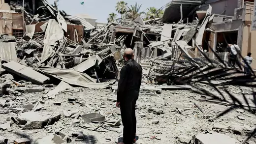 A man stands amidst rubble 