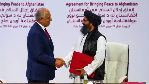 Mullah Abdul Ghani Baradar, the leader of the Taliban delegation, and Zalmay Khalilzad, U.S. envoy for peace in Afghanistan, shake hands.