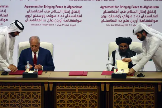 Mullah Abdul Ghani Baradar, leader of the Taliban delegation, signs an agreement with U.S. Special Representative for Afghanistan Reconciliation Zalmay Khalilzad in Doha, Qatar, on February 29, 2020.