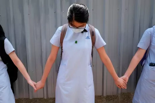 Secondary school students form a human chain near a school campus to protest against a teacher's release over 'her political beliefs' as they said, in Hong Kong.