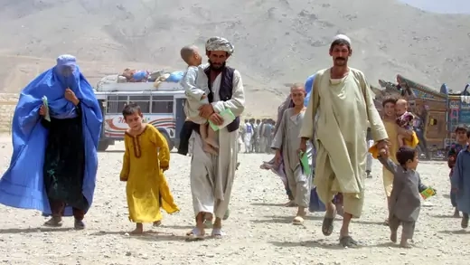 An Afghan refugee family walks toward the camera