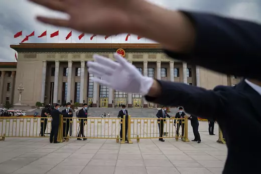 Security guards block a journalist from taking photos in Beijing’s Tiananmen Square.