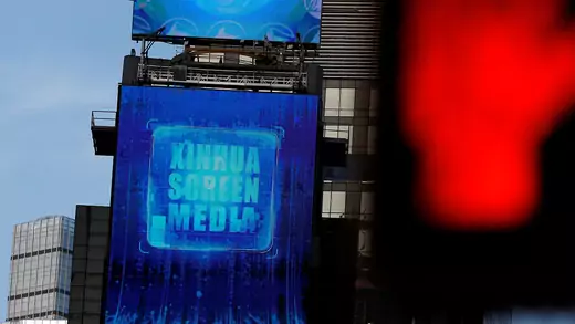 A large screen in New York City's Times Square reads "Xinhua Screen Media."