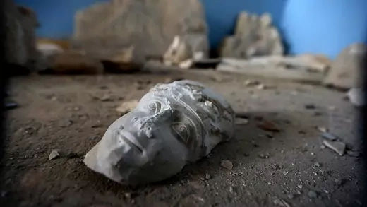 The face of a broken sculpture on the ground