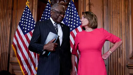 House Majority Whip James Clyburn stands next to Speaker of the House Nancy Pelosi at Capitol Hill with three U.S. flags behind them