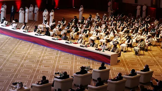 An aerial photo of people sitting in chairs in a conference room in Doha.