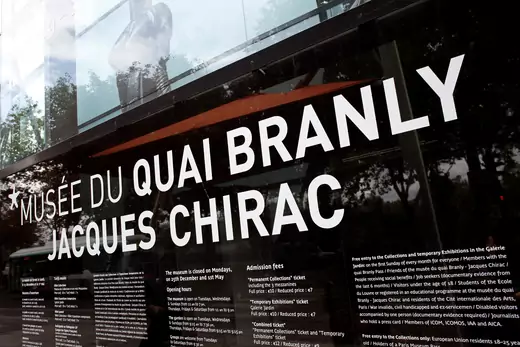 The outside of the Musee du Quai Branly-Jacques Chirac in Paris. The photograph shows a black wall with white writing, spelling out the name of the institution.