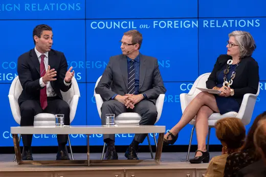 Three panelists in suits sit on white chairs behind a white coffee table against a blue Council on Foreign Relations backdrop.