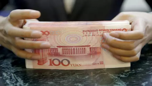 closeup of hands holding 100-yuan notes