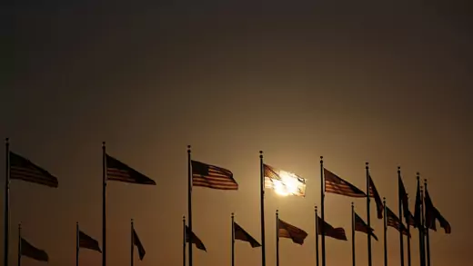 Sun setting behind U.S. flags
