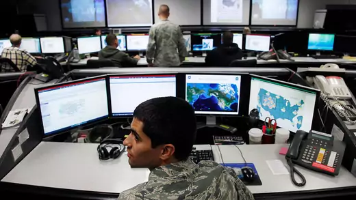 Soldiers sitting in front of rows of computers at the the Air Force Space Command Network Operations & Security Center