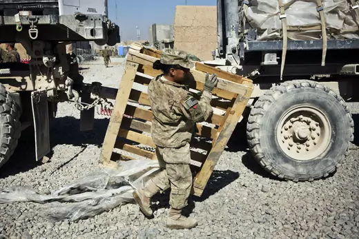 Specialist Joanne Read, of the U.S. Army's Bravo Company, 1st Battalion, 36th Infantry Regiment, First Armored Division, helps unload a resupply truck at Command Outpost AJK in Maiwand District, Kandahar Province, Afghanistan, January 24, 2013. REUTERS/Andrew Burton