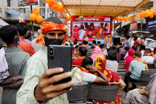 A man takes a selfie during a live screening of a ceremony by Prime Minister Narendra Modi.