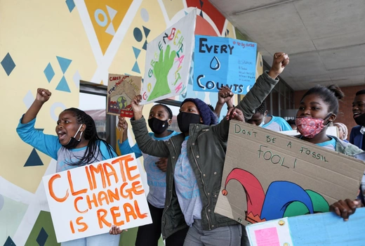 Young activists with masks on gesture with their hands while holding signs while taking part in a climate change demonstration during a global day of action on climate change near Cape Town, South Africa on September 25, 2020. 