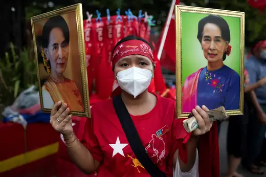 A supporter of National League for Democracy (NLD) holds two portraits of Myanmar State Counselor Aung San Suu Kyi as people gather to celebrate at party headquarters after the general election in Yangon, Myanmar, on November 9, 2020.