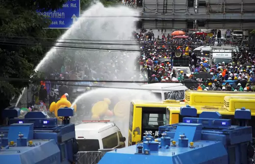 Demonstrators are seen as water cannons are being used during an anti-government protest as lawmakers debate on constitution change, outside the parliament in Bangkok, Thailand, on November 17, 2020.