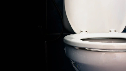 A white toilet with a black background