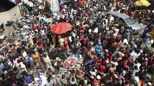 People crowd on a road near Balogun market to shop, a day before Christmas in Nigeria's commercial capital Lagos
