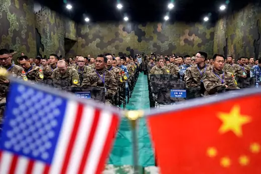 U.S. and Chinese flag cover the foreground of the photo, with the background focused on the U.S. Army and China's People's Liberation Army military personnel attend a closing ceremony of an exercise of "Disaster Management Exchange" near Nanjing, Jiangsu province in China on November 17, 2018. 