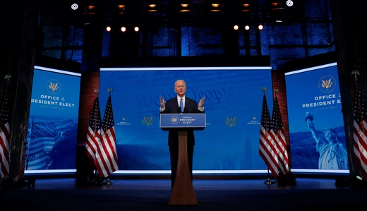 President-Elect Joe Biden stands behind a podium labelled "Office of the President Elect."