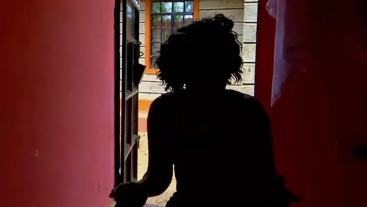 The silhouette of a woman in front of a doorway