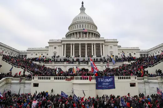 Pro-Trump protestors line the steps of the U.S. Capitol Building waving flags and hanging Trump 2020 banners.