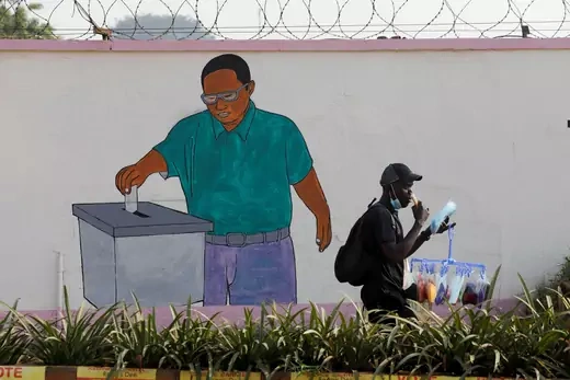 A man walks past a painting on the wall of the Ugandan electoral commission compound in Kampala, Uganda January 13, 2021