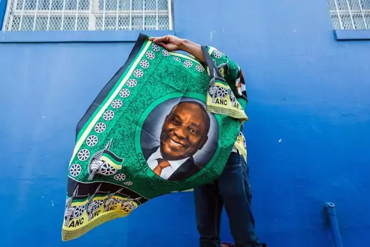 A street vendor sells regalia depicting South African President Cyril Ramaphosa outside the venue for the African National Congress (ANC) 107th anniversary celebrations at the Moses Mabhida Stadium in Durban on January 12, 2019.