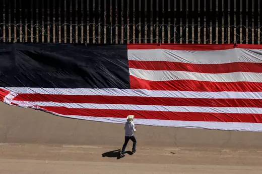 Mexican US resident Roberto Márquez, places a United States national flag on the border wall next to Rio Grande river to demonstrate against the immigration policies of Donald Trump in the border between El Paso, US, and Ciudad Juarez, Mexico, on June 6, 2019.